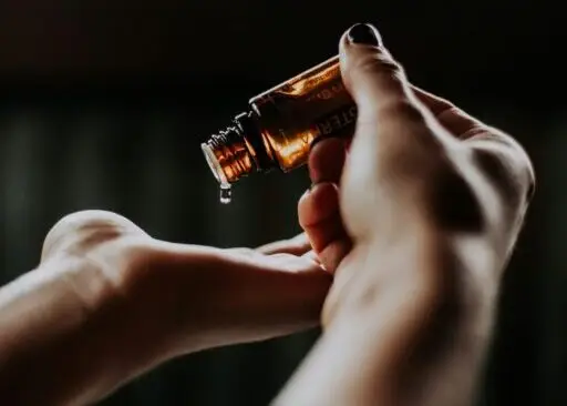 person holding amber glass bottle